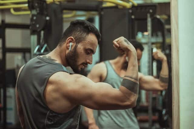 筋肉のパンプアップを確認する男性